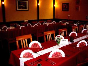 a dining room with tables with red table cloth at Hotel-Restaurant Zum Stern in Baumholder