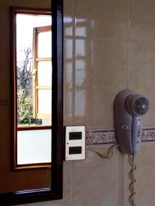 a hair dryer on a wall next to a window at Hostal Torre de Babel in Castro