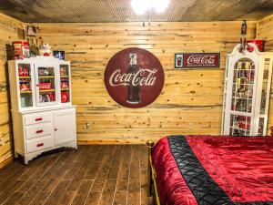 ein Coca-Cola-Schild an der Wand eines Schlafzimmers in der Unterkunft Samantha's Timber Inn in Murfreesboro
