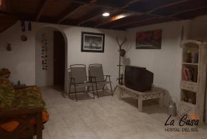 a living room with two chairs and a television at La casa de Hostal del Sol in Rosario