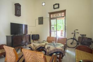 Habitación con mesa, sillas y TV. en RedDoorz @ Letjend S. Parman Pacitan, en Pacitan