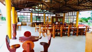 um restaurante com mesas e cadeiras de madeira e uma mesa em Pousada Chácara Lago Seco em Camocim