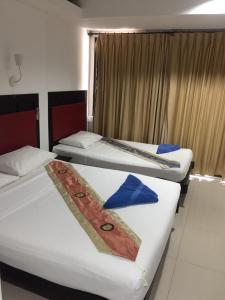 two beds in a hotel room with towels on them at Boomerang Inn in Patong Beach
