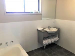 a bathroom with a toilet, sink and tub at Bathurst Motor Inn in Bathurst