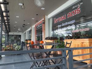a restaurant with tables and chairs in front of a store at สตาร์ รีสอร์ท (สี่แยก จปร) in Nakhon Nayok