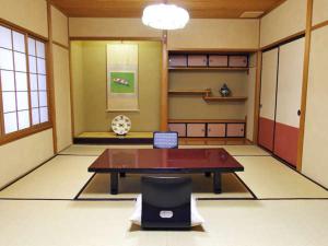 a room with a table and a chair in it at Shouheikaku in Matsue