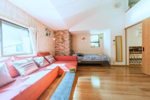 ein Wohnzimmer mit einem roten Sofa und einem Bett in der Unterkunft nestay house tokyo itabashi 02 in Tokio