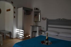 a bedroom with a bed with a bottle of champagne at Skyros Koxilas Studios in Skiros