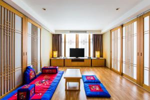 a living room with a couch and a tv at Hidden Bay Hotel in Yeosu