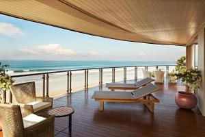 a balcony with chairs and a view of the beach at Double - Six, Luxury Hotel - Seminyak in Seminyak