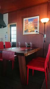 富士吉田的住宿－Tsukitei1，酒吧设有两把红色椅子和一张带酒杯的桌子