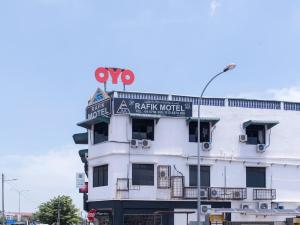 ein weißes Gebäude mit einem Schild darüber in der Unterkunft OYO 44016 Rafik Ali Motel in Kepala Batas