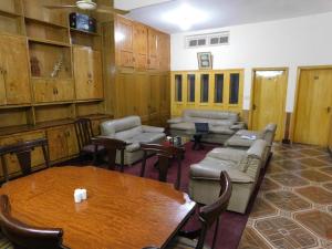 una stanza con tavolo, divani, tavolo e sedie di The City Lodge a Islamabad