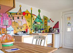 a kitchen with a painting on the wall at Gästeapartement Schlossblick in Kapfenstein