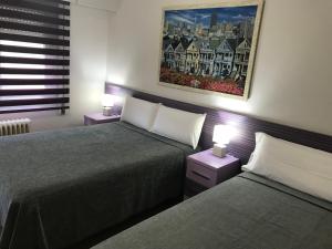 a bedroom with two beds and two lamps on tables at Pension Berceo in Logroño