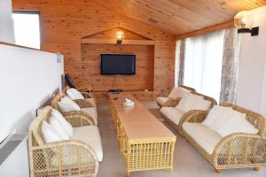 a living room with wicker chairs and a tv at Taiyou no Ouchi in Tonosho