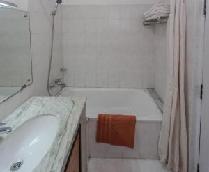 La salle de bains est pourvue d'une baignoire blanche et d'un lavabo. dans l'établissement Fuji Hotel, à Katmandou