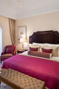 a bedroom with a large bed with a pink blanket at The Taj Mahal Palace, Mumbai in Mumbai