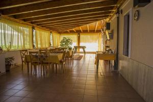 a dining room with tables and chairs and yellow curtains at Villa Benice in Morino