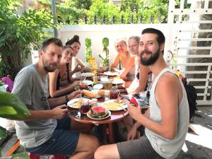 a group of people sitting around a table eating food at PaPa Villa Homestay in Hoi An