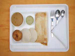a styrofoam plate of food with bread and dips at Shanthi Residency in Pathanāmthitta