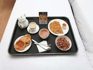 Hotel Delight في أودايبور: صينية طعام مع طعام الإفطار عليها
