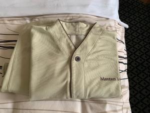 a tan leather jacket sitting on top of a bed at Kanazawa Manten Hotel Ekimae in Kanazawa