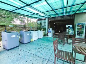 a patio with several washers and dryers and a table and chairs at Tree Boutique Residence - Quiet Oasis - Stunning View, Pool & Gym in Chiang Mai