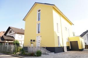 a yellow and white house with a driveway at Ferienwohnung Paula in Lahr