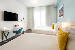 um quarto de hotel com uma cama e uma secretária em President Hotel em Miami Beach