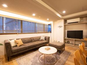 nid OSAKA Atre Nakatsu في أوساكا: غرفة معيشة بها أريكة وطاولة