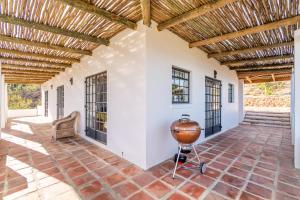an outdoor patio with a wooden ceiling and a grill at Druk My Niet Wine Estate in Paarl