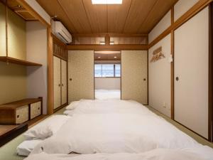 nid OSAKA Atre Nakatsu في أوساكا: غرفة نوم فيها سريرين كبار بيض