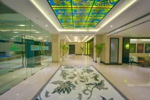 a lobby with a colorful ceiling and a hallway with a rug at Lemon Tree Hotel Jammu in Jammu