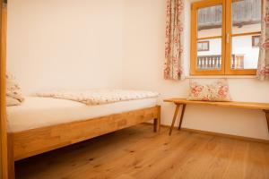 Schlafzimmer mit einem Bett und einem Fenster in der Unterkunft Ferienwohnung Glaserhäusl am Roßgarten in Schliersee