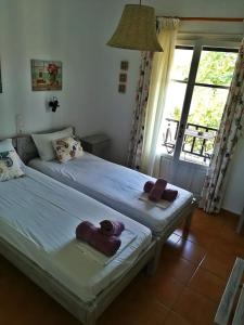 um quarto com 2 camas e toalhas em Zaira Studios em Skala Eresou