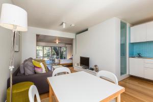 a living room with a couch and a table at Cottesloe Tree Top Studio in Perth