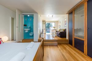 
a room with a bed, a refrigerator, and a window at Cottesloe Tree Top Studio in Perth
