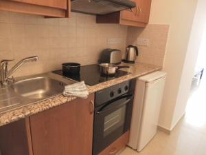 a kitchen with a sink and a stove top oven at Studio, E104 with double bed, kitchen & shower room, sunny balcony in Peyia