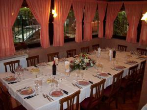 a long table with white tablecloths and flowers on it at Abba Camere in Borgaro Torinese