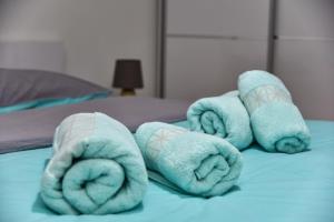 einen Haufen Handtücher auf dem Bett in der Unterkunft Lux Apartment Flatiron Skopje in Skopje