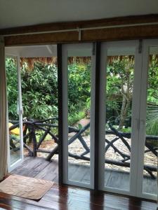an open sliding glass door to a patio with a table at Baan Pong Tara in Suan Phung