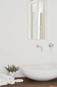bagno con lavandino bianco e specchio di Villa Canisello a Noto