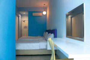 Habitación azul con cama y mesa con silla en YY38 Hotel, en Kuala Lumpur