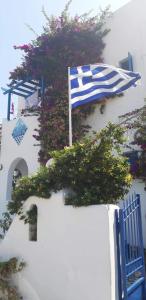 Bandera azul y blanca en el lateral de un edificio en Pelagos Studios, en Parikia