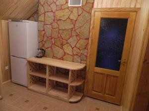 una cocina con nevera y un banco junto a una puerta en Гостевая усадьба Родовое гнездо, en Haysyn