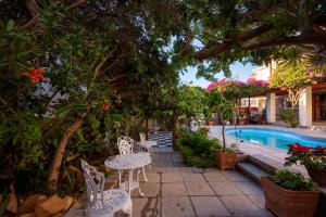un patio con mesas y sillas junto a una piscina en The Cheriton Guest House, en Simonʼs Town