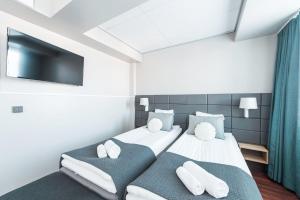 赫尔辛基Forenom Aparthotel Helsinki Kamppi - contactless check-in的一间卧室，配有两张床和一台平板电视