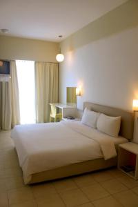 a bedroom with a large white bed and a desk at YY38 Hotel in Kuala Lumpur