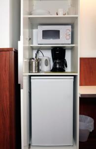 a small kitchen with a microwave and a refrigerator at Forenom Aparthotel Helsinki Kamppi - contactless check-in in Helsinki